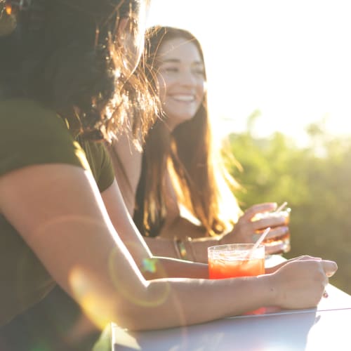 Resident friends enjoying drinks outside on a beautiful day at Legends at Pine Forest in Pensacola, Florida
